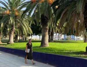 alieke loopt door het park in valencia met haar laptop