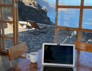 werken op de laptop met uitzicht op zee