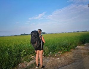 alieke met backpack naast een rijstveld