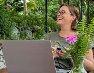 Nancy aan het werk op haar laptop in de tuin