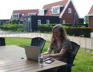 Julia werkt op haar laptop op een vakantiepark