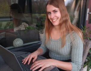 Julie werkt op haar laptop in de tuin