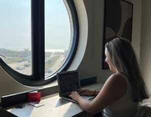 working on laptop in hotel room overlooking sea