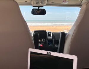 working on the laptop in the motorhome overlooking the sea