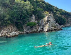 danielle lies in the water next to rocks