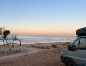 camper aan het strand met zonsondergang