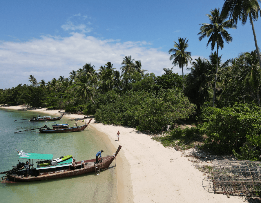 Bounty beach in Thailand with fishing boats and palm trees