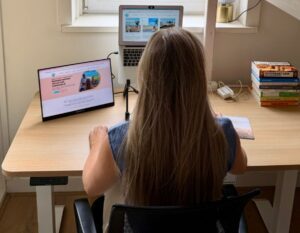 alieke zit te werken aan het sta-zit bureau op 2 schermen