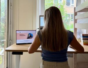 alieke staat te werken aan het sta-zit bureau op 2 schermen
