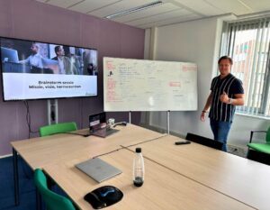 Henno is giving a presentation in a conference room