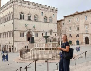 Romee in Italy, in a square in front of a beautiful historic building