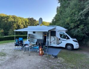camper van henno op een veld met tafels en stoelen