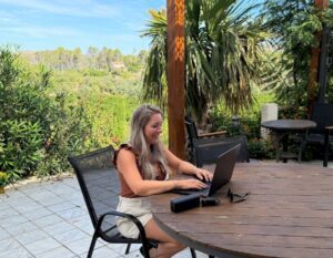 alieke werkt remote op het terras met haar laptop en powerbank